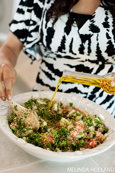 Pouring the olive oil on the Tabbouleh.